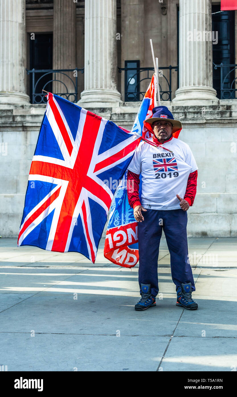 Un uomo nero che porta la bandiera di Union Jack e indossa una maglietta pro Brexit, Trafalgar Square, Londra, Inghilterra, Regno Unito. Foto Stock