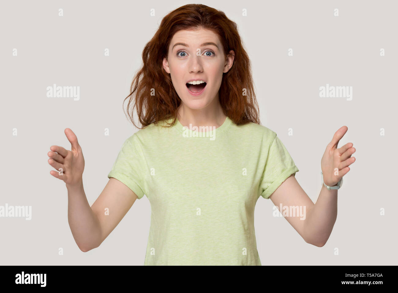 Emozionato redhead girl mostrare grandi dimensioni misurazione con le mani Foto Stock