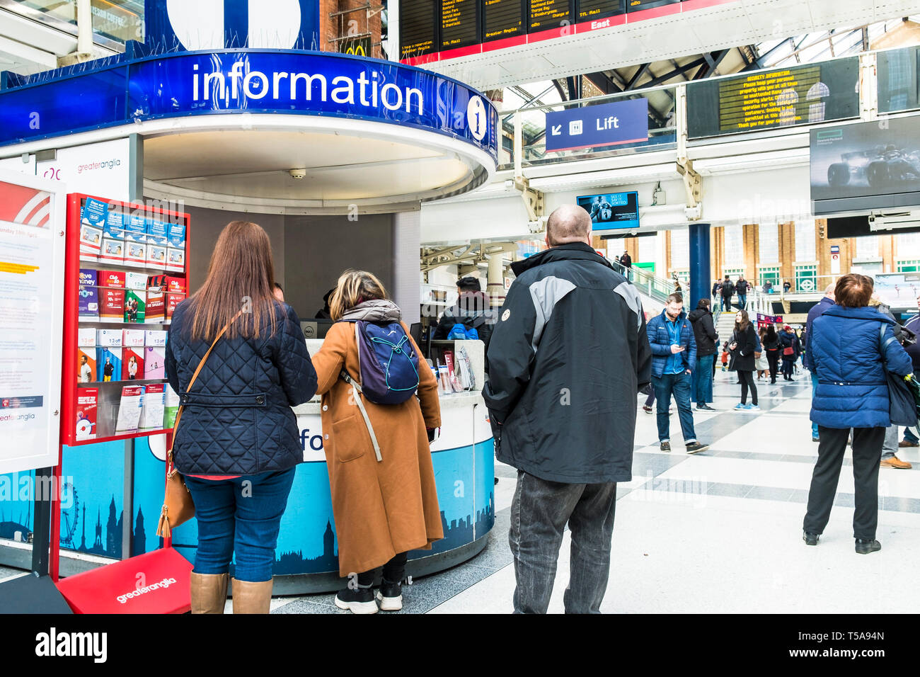 Passeggeri domandando presso il banco informazioni dell'atrio a Liverpool Street Station di Londra. Foto Stock
