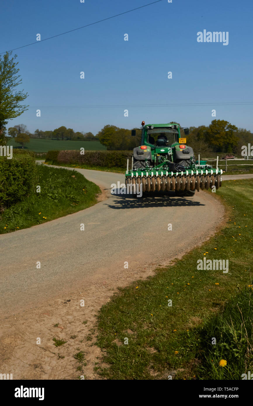 Macchine agricole su una strada con curve nel Kent con un blu cielo sereno sfondo, Kent, England, Regno Unito, Europa Foto Stock