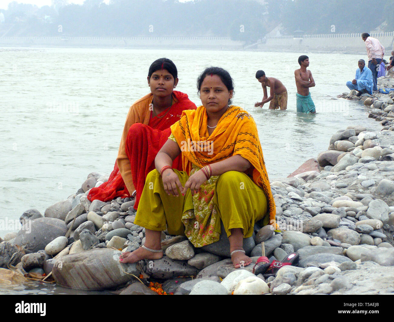 AMRITSAR, INDIA, DEC-7, 2015: non identificato due donne indiane in sari sono seduto su una roccia vicino all'acqua. Foto Stock