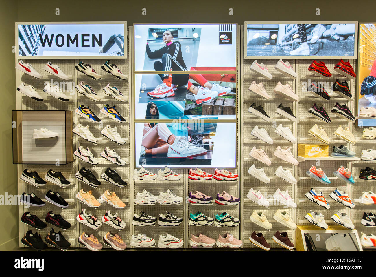 Scarpe sportive o sneakers da donna in mostra ordinatamente nel negozio Foot Locker, Singapore. Foto Stock