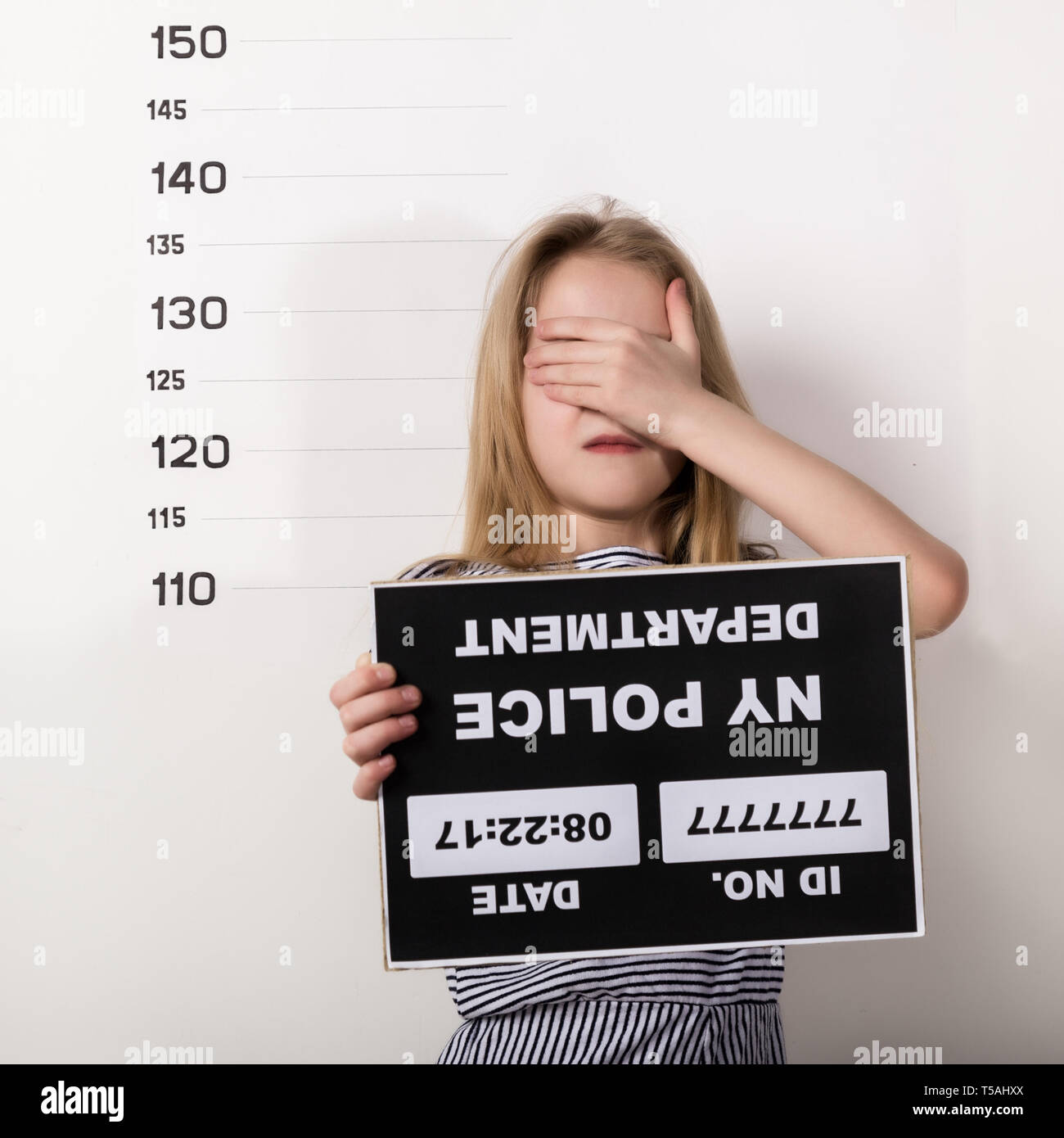 Giovane bella bionda bambino con un segno, Penale mug shots Foto Stock