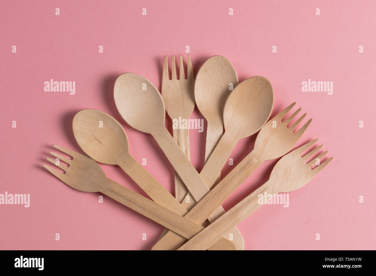 Fiore dal cucchiai e forchette, una ventola di utensili in legno isolato su sfondo rosa Foto Stock