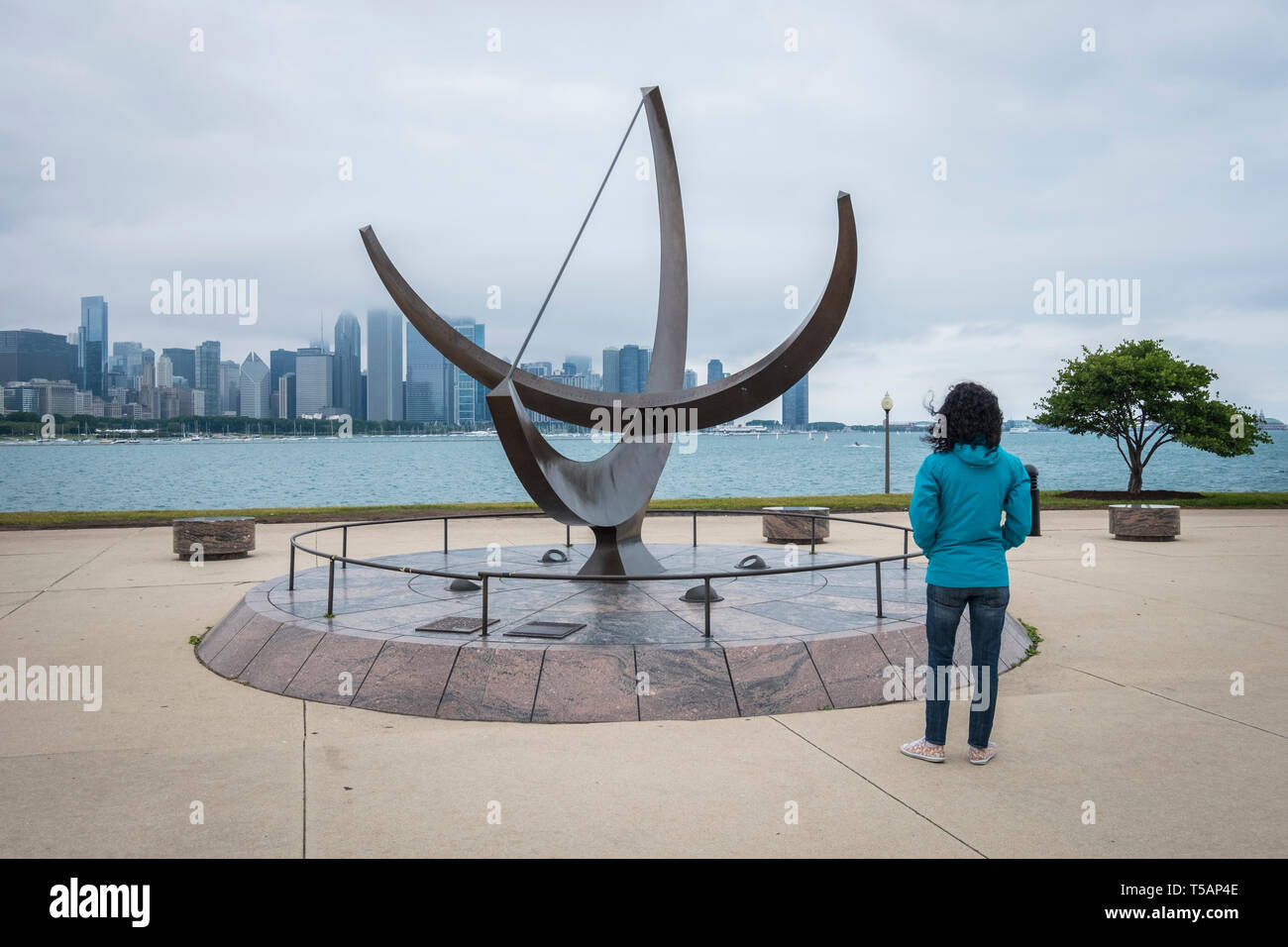 La donna guarda l'uomo entra nel cosmo scultura accanto al Planetarium Adler con sullo skyline di Chicago in background Foto Stock