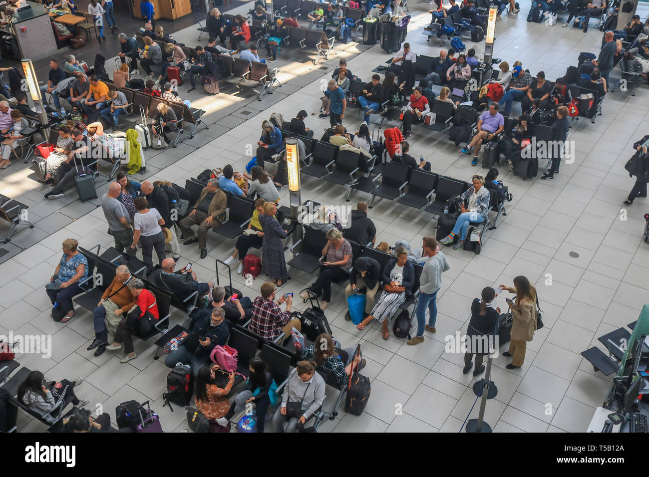 Londra, Regno Unito. 22 apr, 2019. I passeggeri in attesa nella sala partenze in una trafficata Pasqua lunedì festivo come aeroporto di Heathrow annuncia un aumento del numero di passeggeri per la ventinovesima mese in una fila come 6,5 milioni di passeggeri passati attraverso il Regno Unito aeroporto più trafficato di marzo, una media di 210.000 al giorno. L'aumento è stato 0,5 per cento rispetto allo stesso mese del 2018, che rappresenta un ulteriore 1.000 passeggeri al giorno. Credito: amer ghazzal/Alamy Live News Foto Stock