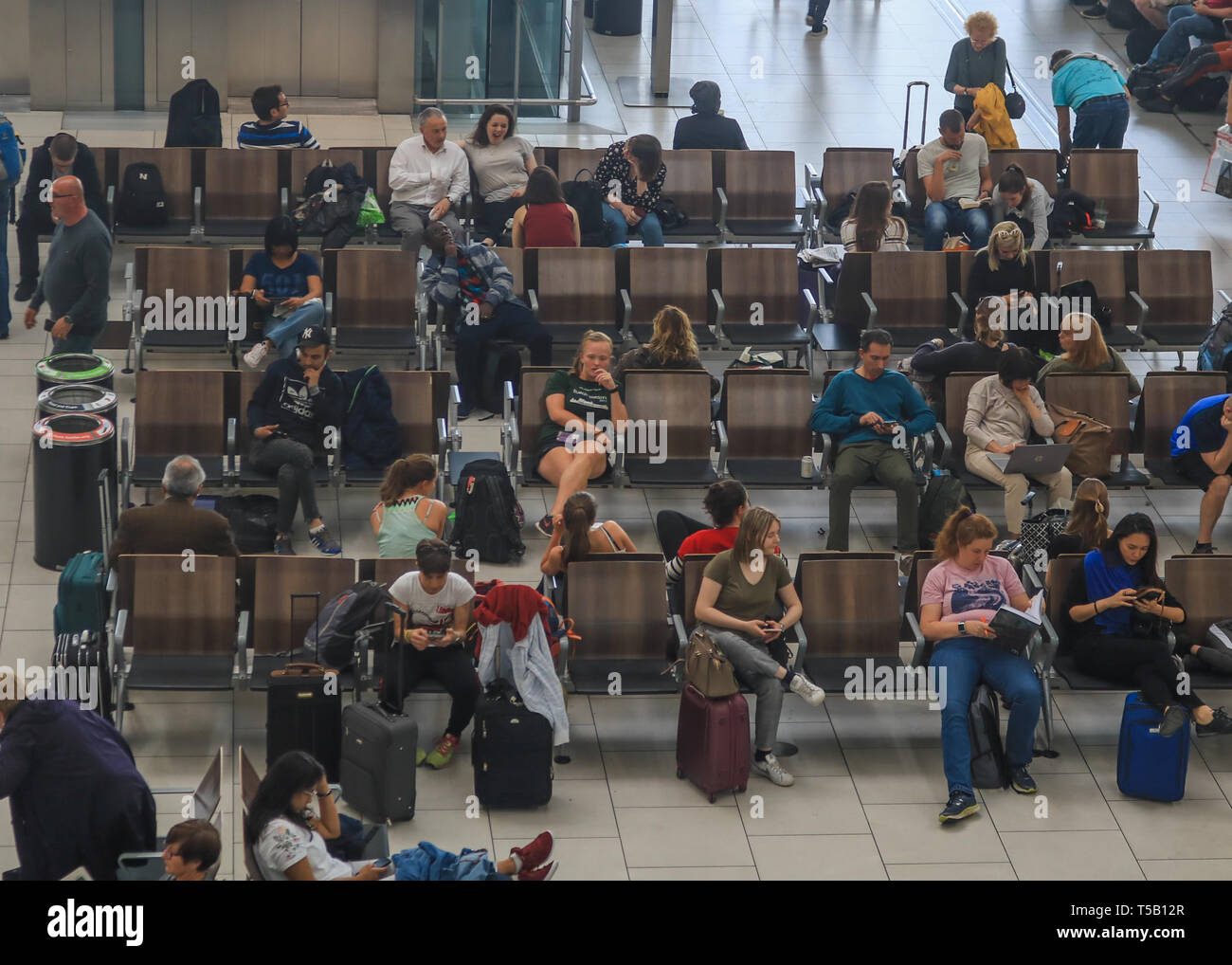 Londra, Regno Unito. 22 apr, 2019. I passeggeri in attesa nella sala partenze in una trafficata Pasqua lunedì festivo come aeroporto di Heathrow annuncia un aumento del numero di passeggeri per la ventinovesima mese in una fila come 6,5 milioni di passeggeri passati attraverso il Regno Unito aeroporto più trafficato di marzo, una media di 210.000 al giorno. L'aumento è stato 0,5 per cento rispetto allo stesso mese del 2018, che rappresenta un ulteriore 1.000 passeggeri al giorno. Credito: amer ghazzal/Alamy Live News Foto Stock
