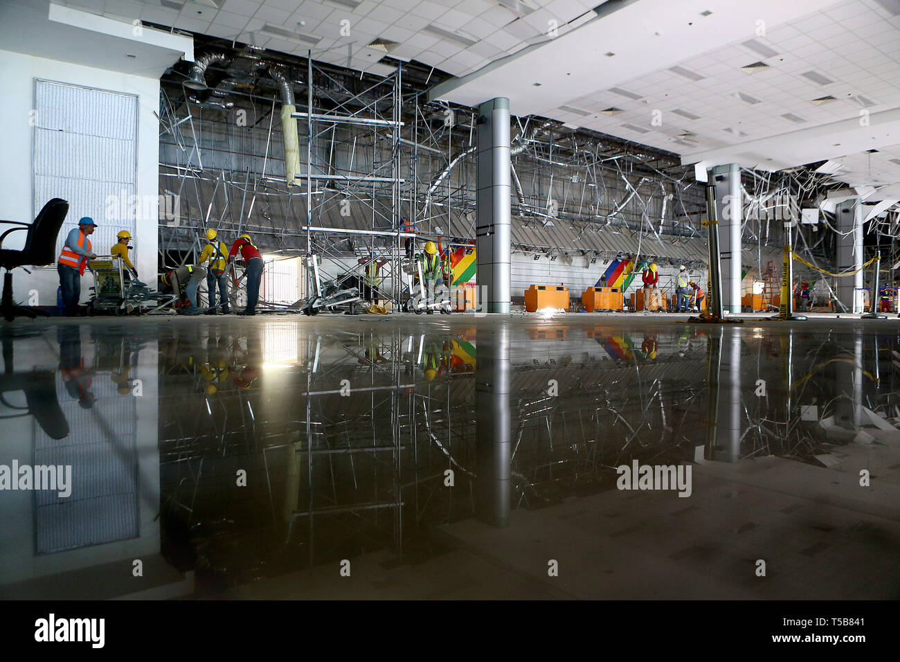 Pampanga, Filippine. 23 apr, 2019. Lavoratori chiaro il soffitto crollato del Clark International Airport dopo un terremoto nella provincia di Pampanga, Filippine, 23 aprile 2019. Il tributo di morte pagato lunedì l'6,1-grandezza scossa di terremoto che ha colpito le Filippine Nord è salito a 16, la Philippine National la riduzione del rischio di calamità e il Consiglio di Gestione ha detto martedì. Credito: ROUELLE UMALI/Xinhua/Alamy Live News Foto Stock