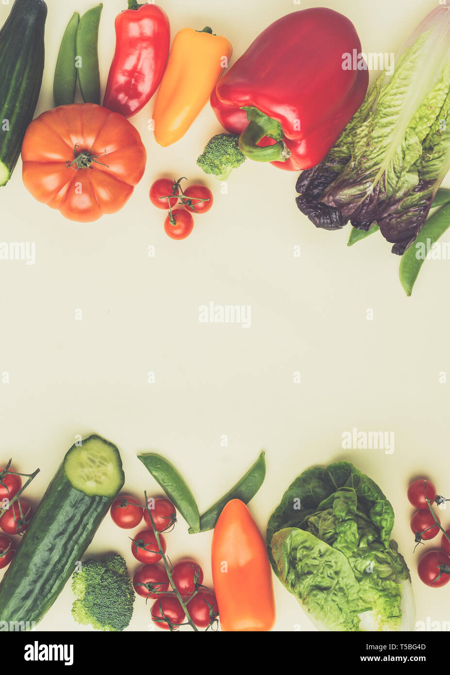 Freschi ingredienti grezzi per insalata Pomodori Cetrioli insalata di avocado pepe cipollina broccoli piselli sulla tavola di crema, vista dall'alto, tonica, il fuoco selettivo Foto Stock