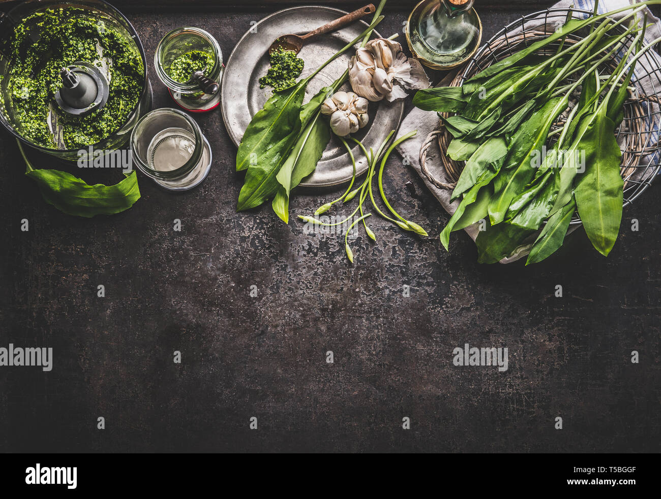 Ramson, aglio selvatico, pesto con ingredienti on dark cucina rustica sfondo tabella, vista dall'alto, di confine. Copia dello spazio per il vostro design, testo o ricette. Sp Foto Stock