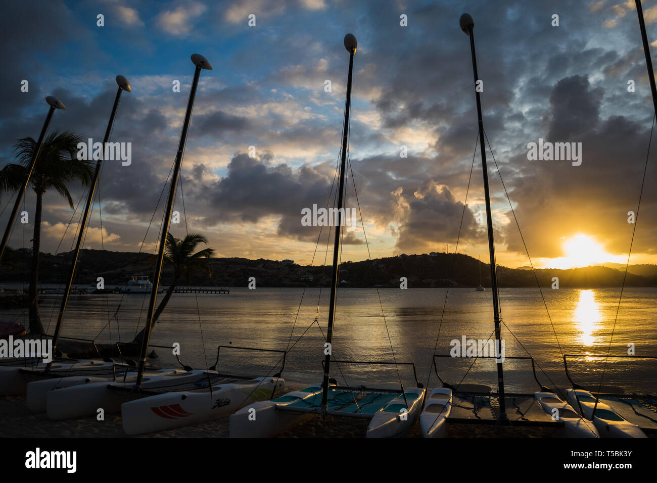 Il sole tramonta dietro una linea di imbarcazioni in Antigua Foto Stock