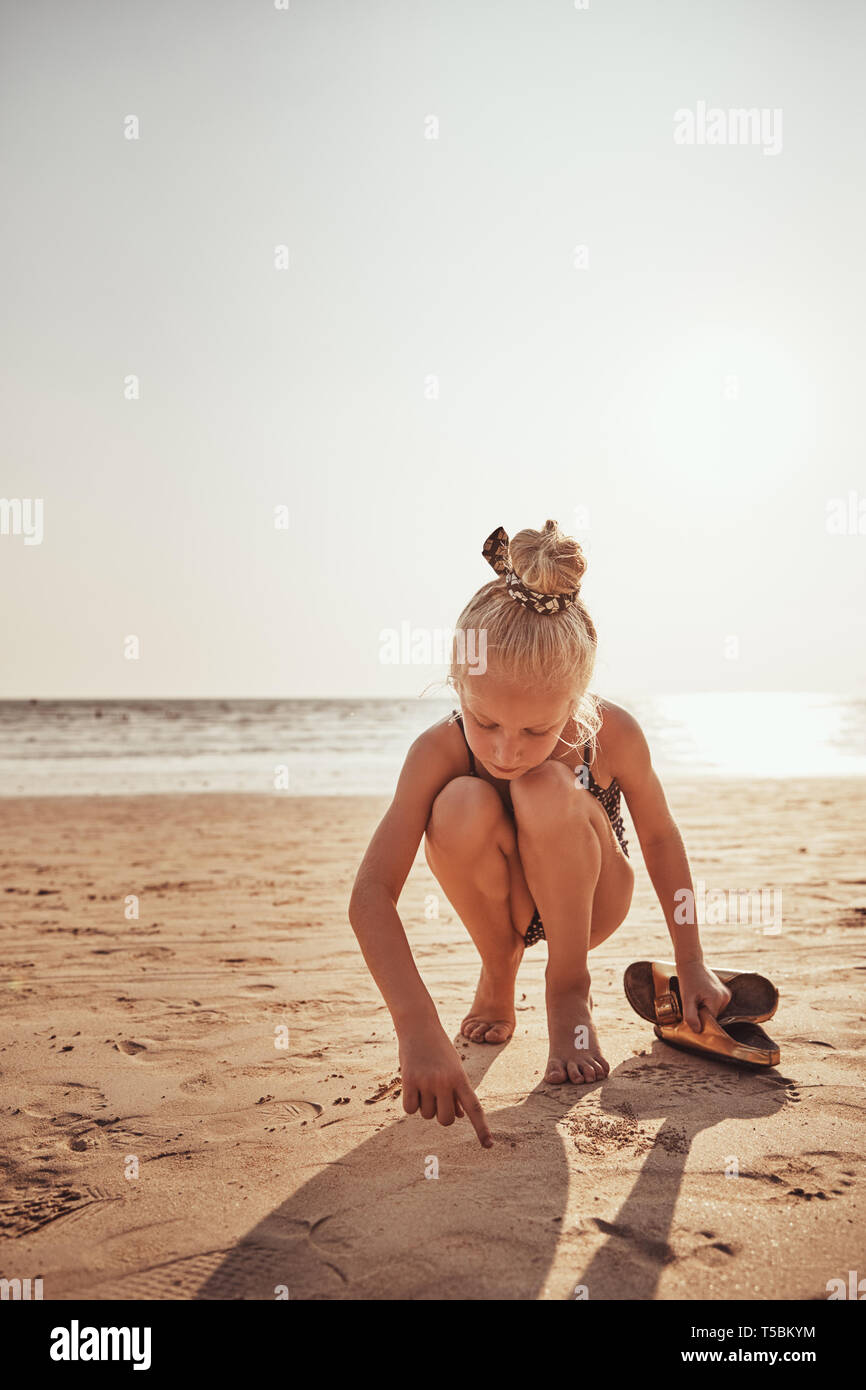 Adorabile bambina in una riproduzione del costume da bagno di sabbia su una  spiaggia in estate Foto stock - Alamy