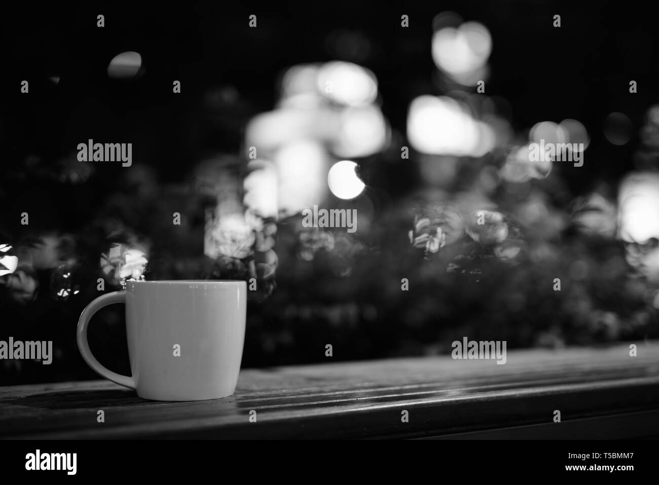 Tazza di caffè sul tavolo di legno nel ristorante di notte Foto Stock