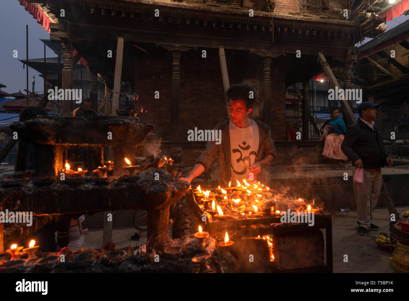 KATHMANDU, NEPAL - MARZO 30, 2019: un uomo sta prendendo auto di burro di candele, prese al tramonto a Durbar Square nel cuore del centro storico di Kathmandu Foto Stock