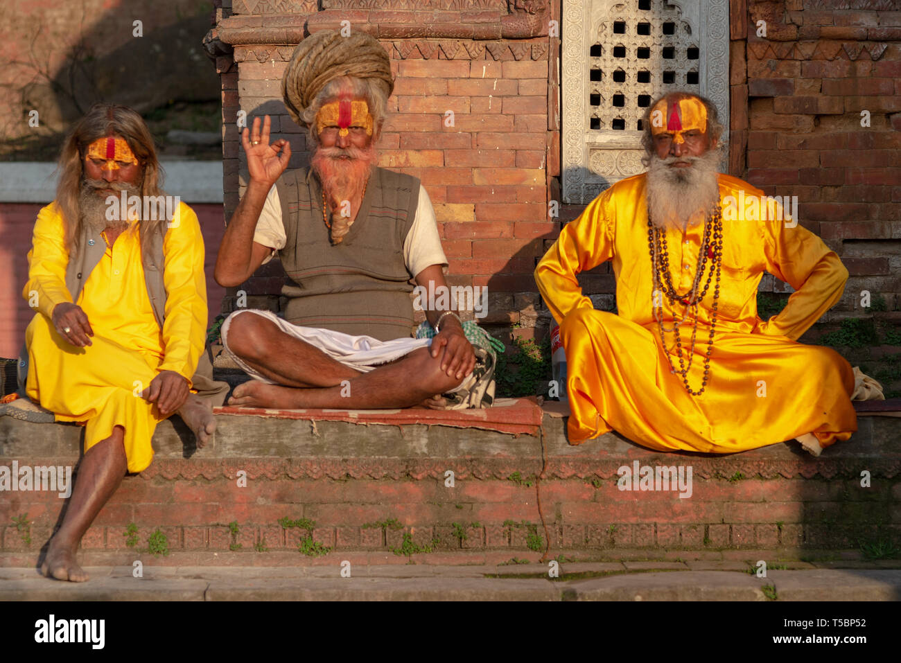 TILGANGA, Kathmandu, Nepal - Aprile 2, 2019: un gruppo di 3 Sadhus posa per la fotocamera Foto Stock