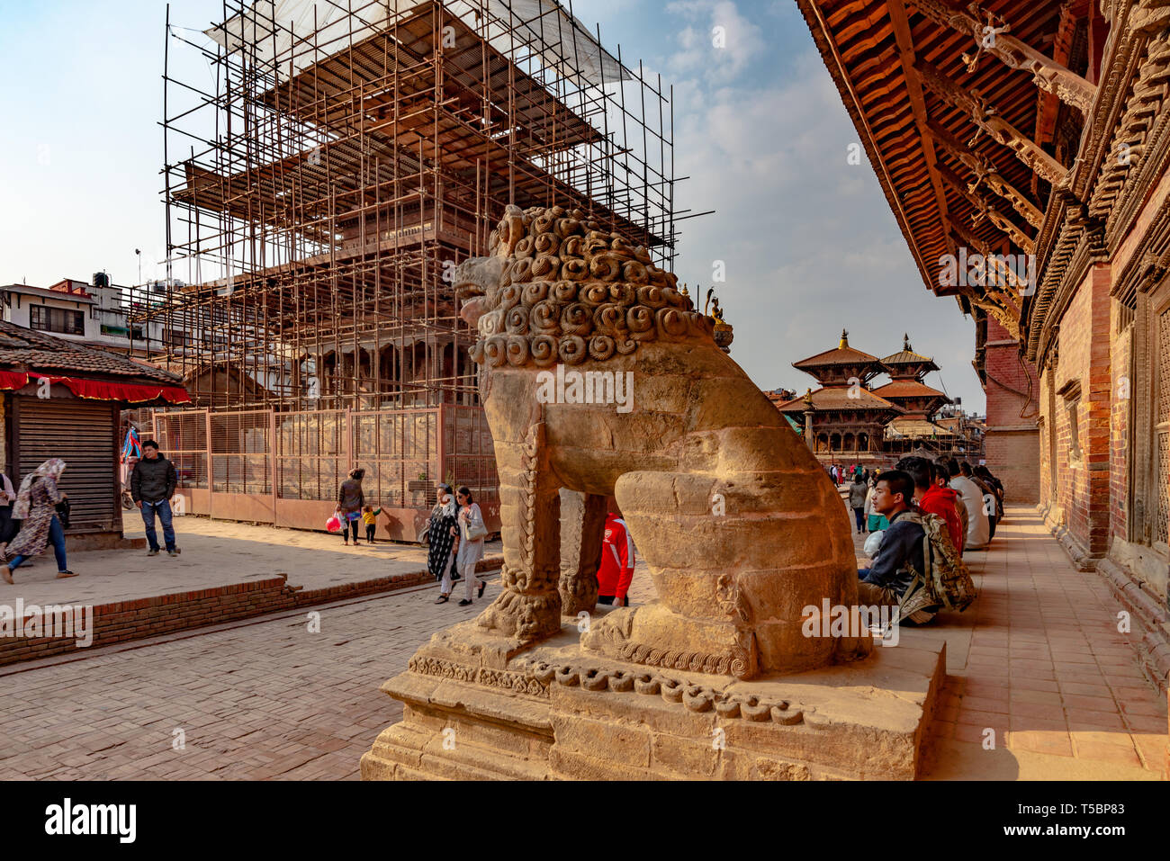 LALITPUR, PATAN NEPAL - Aprile 3, 2019: Lion guard e un tempio in ricostruzione dopo il terremoto 2015, adottate in Durbar Square Foto Stock