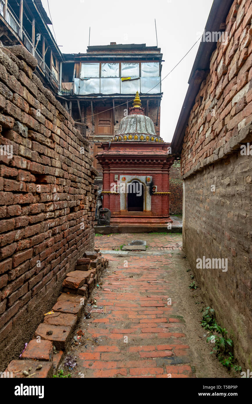 Piccolo ornata tempio rosso presi durante una parzialmente soleggiato mattina nel centro storico di Bhaktapur, Nepal Foto Stock