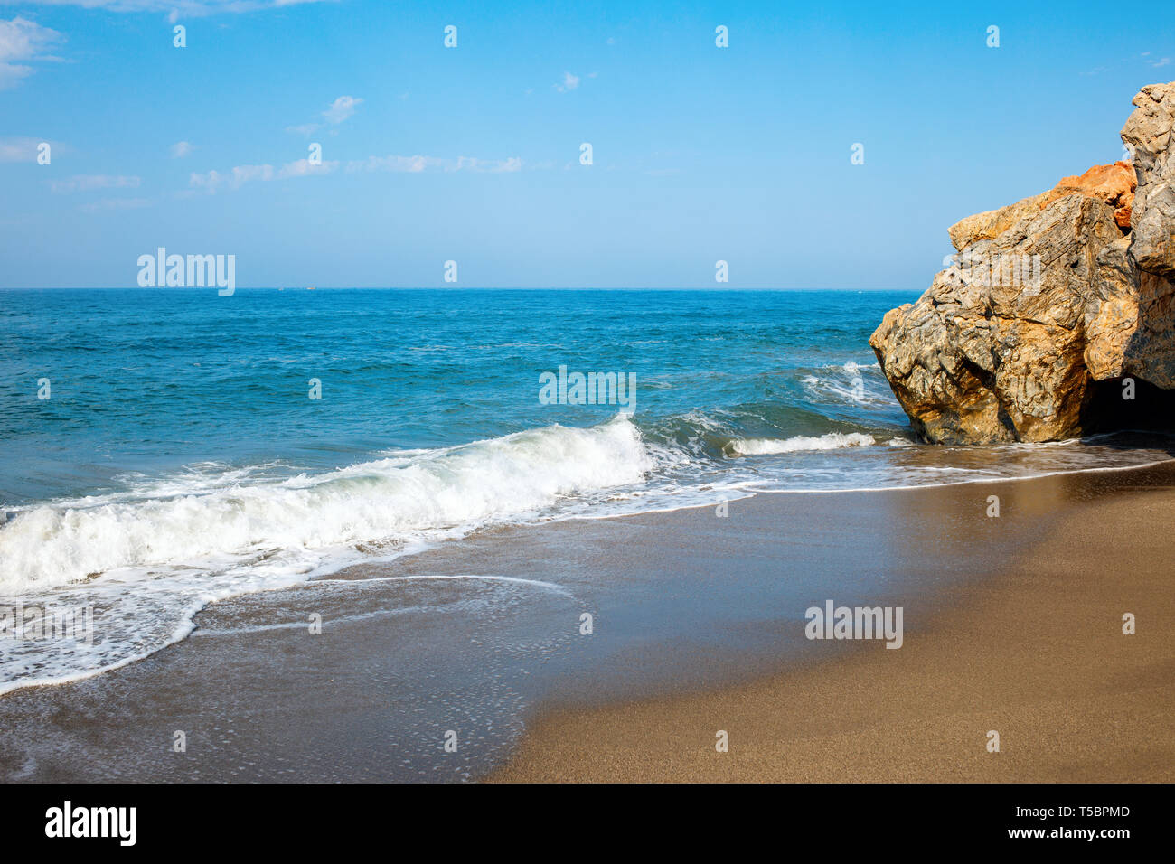 Spiaggia di sabbia morbida e blu oceano onda con schiuma bianca. Foto Stock