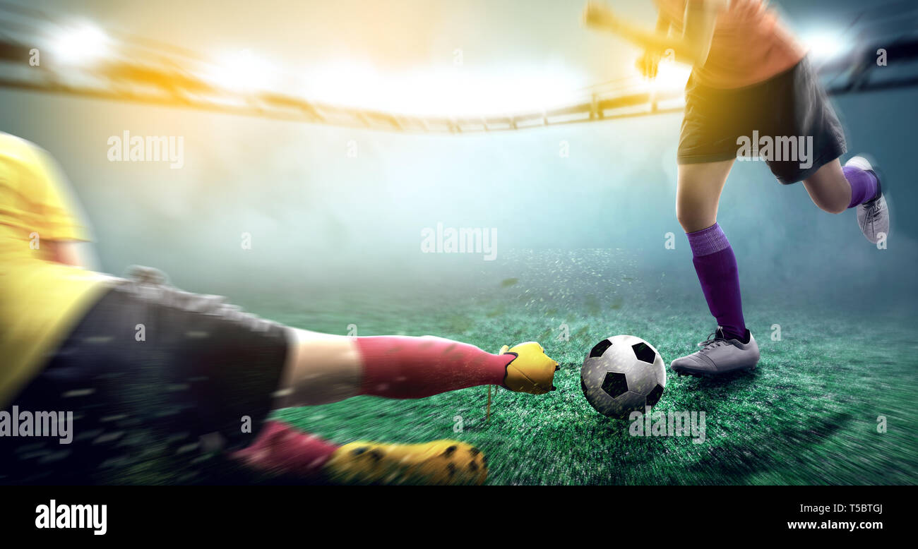 Giocatore di football donna in maglia gialla scivolata la palla al suo avversario sul campo di calcio a Stadium Foto Stock