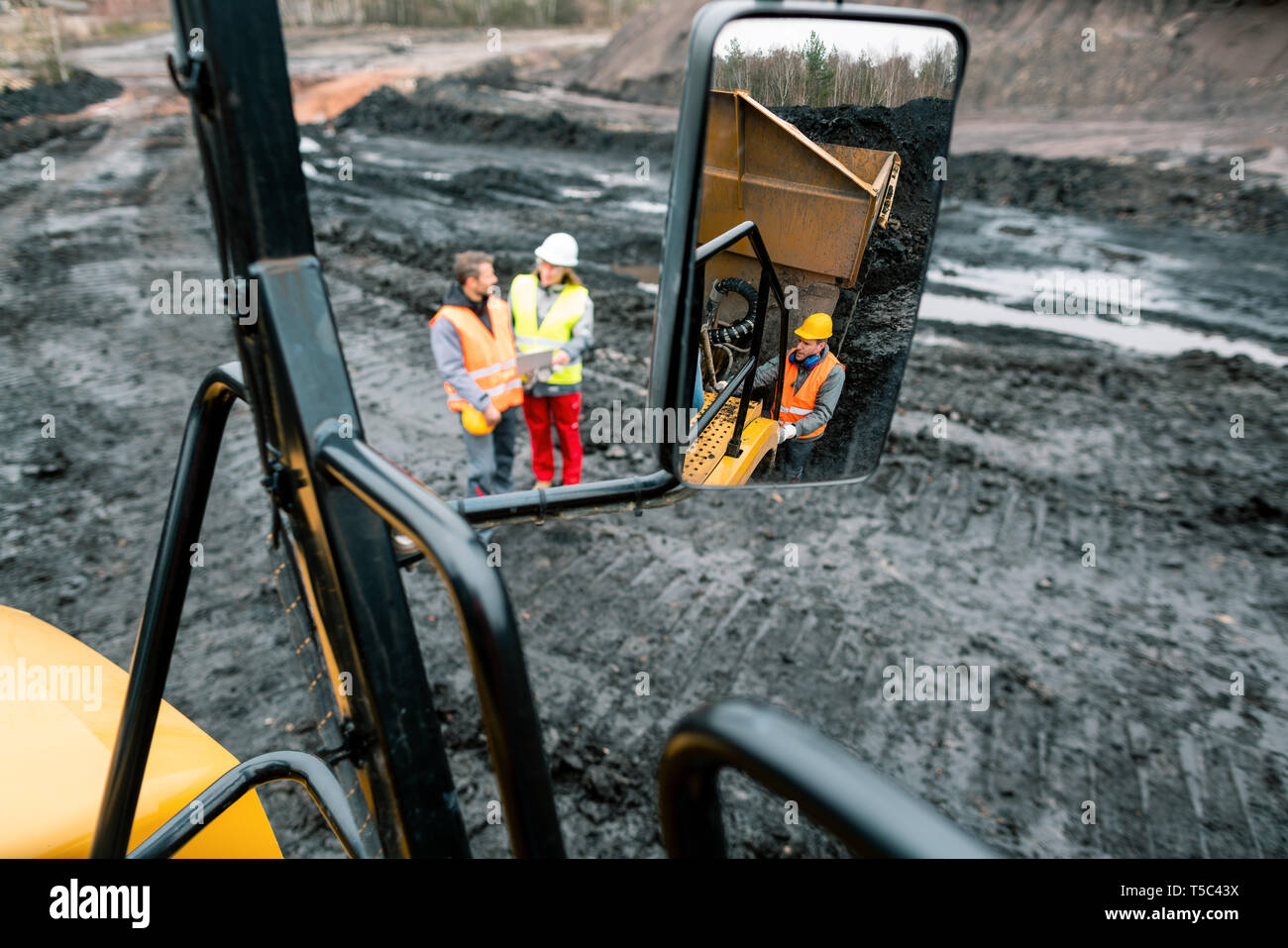 I lavoratori in quarry visto nello specchio di un camion pesanti Foto Stock