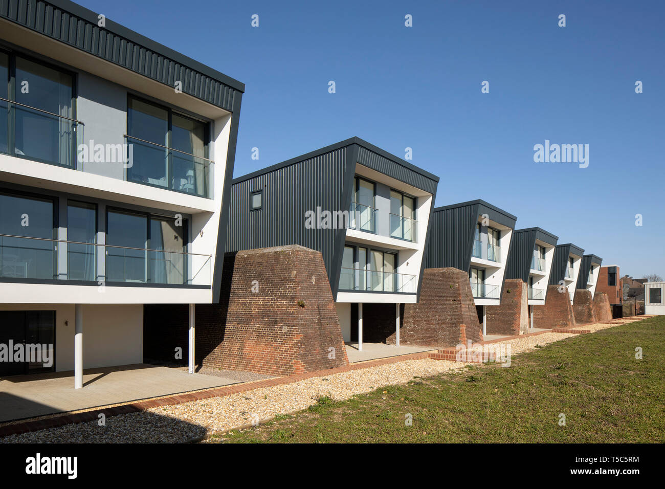 Vista anteriore della fila di case da una fine. Priddys Hard, Gosport, Regno Unito. Architetto: John Pardey architetti, 2019. Foto Stock