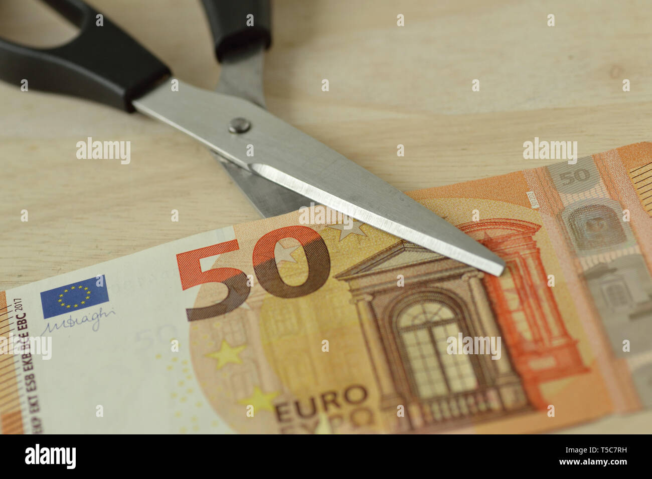 Il taglio a forbice di banconote in euro - Concetto di riduzione dei costi, il taglio dei prezzi Foto Stock