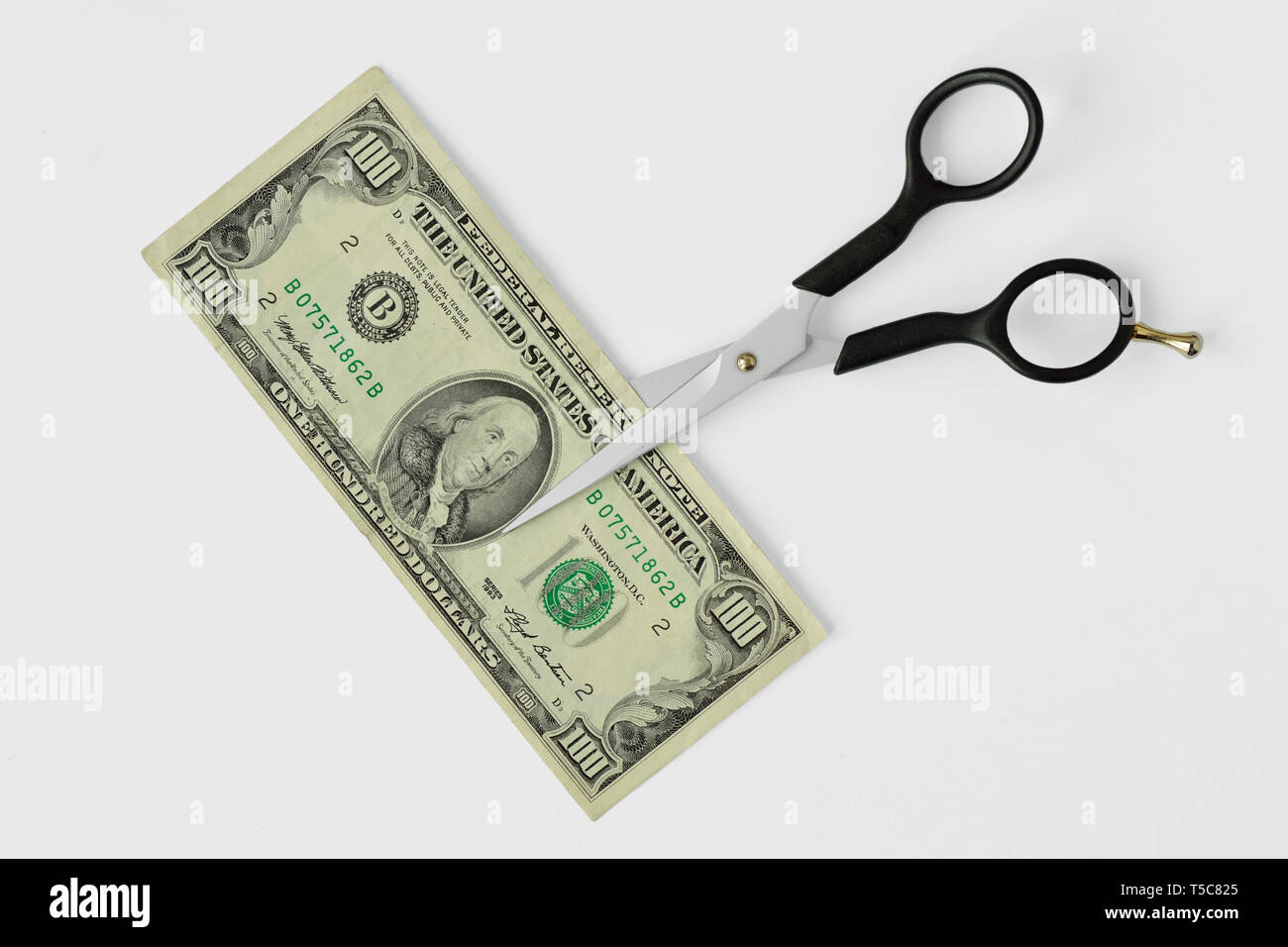 Forbici da taglio di banconote di dollari su sfondo bianco - Concetto di riduzione dei costi, il taglio dei prezzi Foto Stock