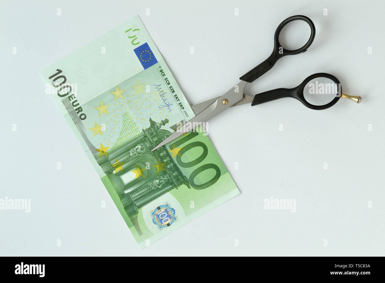 Il taglio a forbice di banconote in euro - Concetto di riduzione dei costi, il taglio dei prezzi Foto Stock