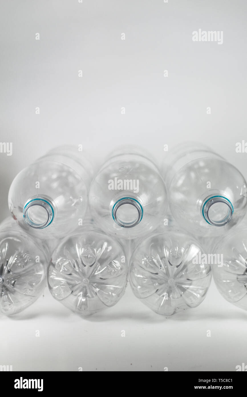 Pila di confezione di un litro e mezzo di vuoto di acqua minerale senza tappi con il solo blu anello di tenuta su uno sfondo bianco e lo spazio per gli inserti Foto Stock