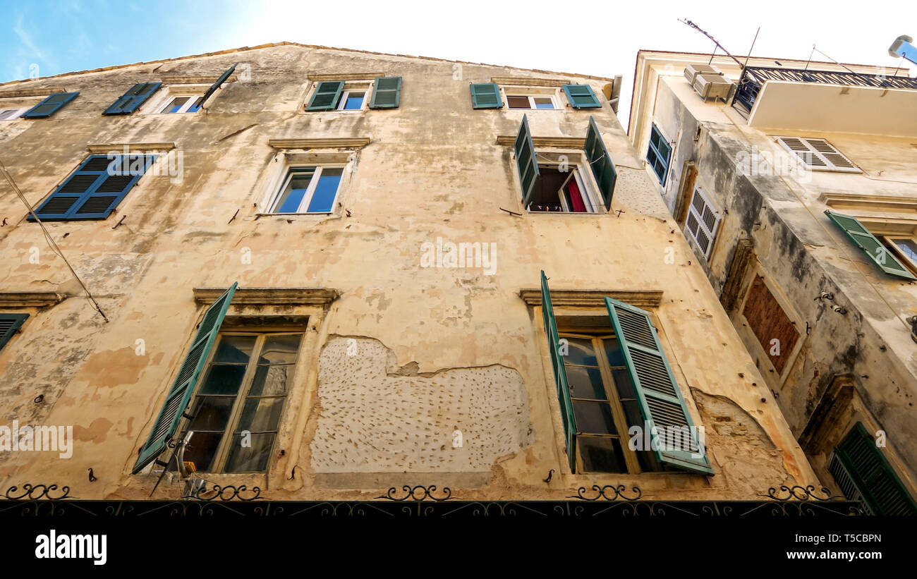 Windows di Weathered Edificio di appartamenti nella città vecchia di Corfù, Grecia Foto Stock
