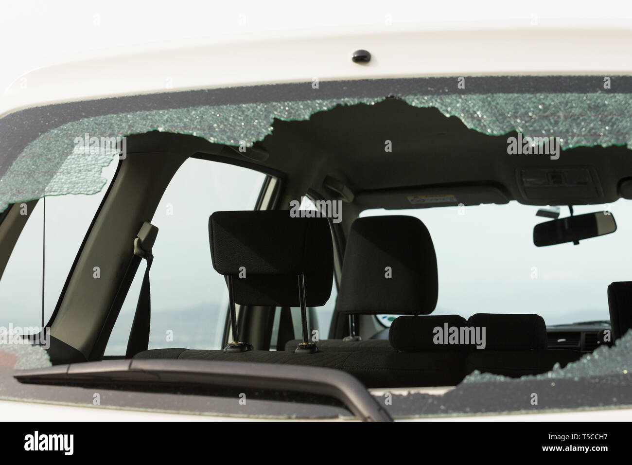 In frantumi o rotto posteriore o di vetro di finestra su una vettura bianca a causa di un furto o furti o atti di vandalismo in una zona urbana di Città del Capo in Sud Africa Foto Stock