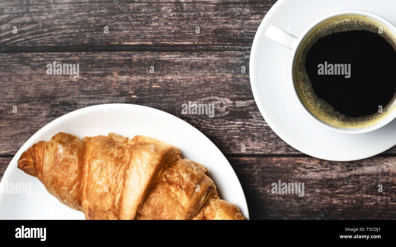 Colazione perfetta con dei croissant e caffè sul tavolo di legno. Stile rustico. Foto Stock