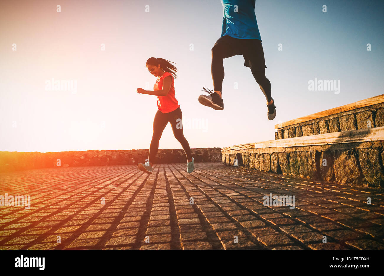 Montare la salute coppia giovane correndo insieme durante un magnifico tramonto - Atletica amici facendo sport outdoor Foto Stock
