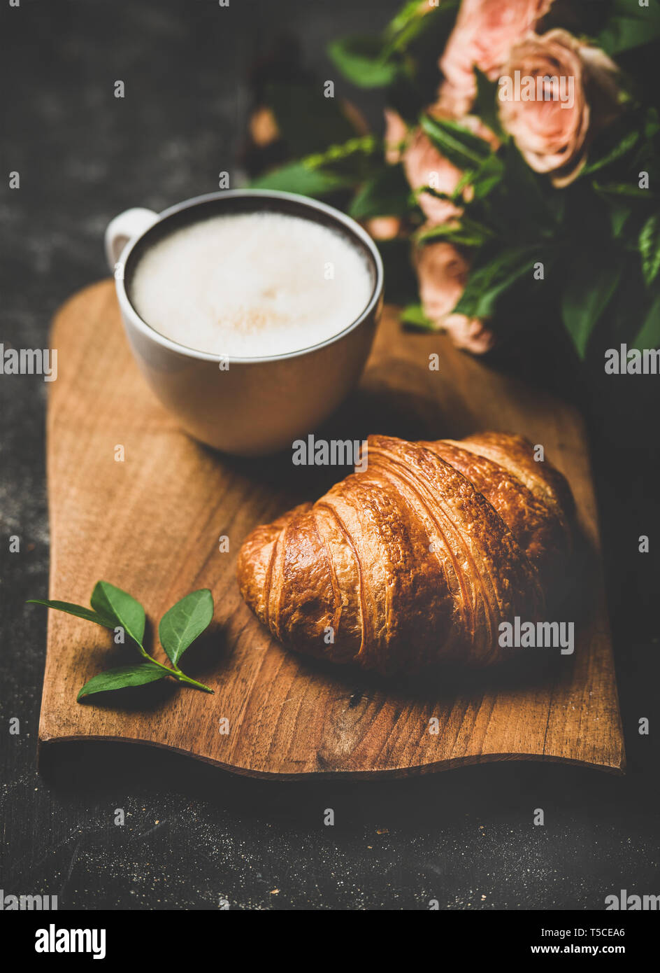Pausa caffè con cappuccino e croissant e rosa fiori di primavera Foto Stock