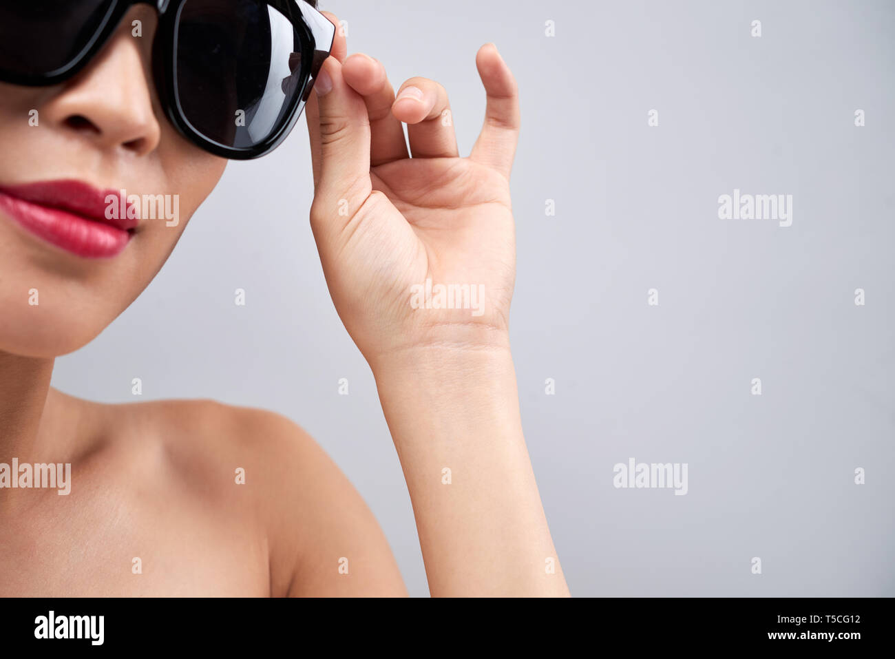 Donna che indossa gli occhiali da sole alla moda Foto Stock