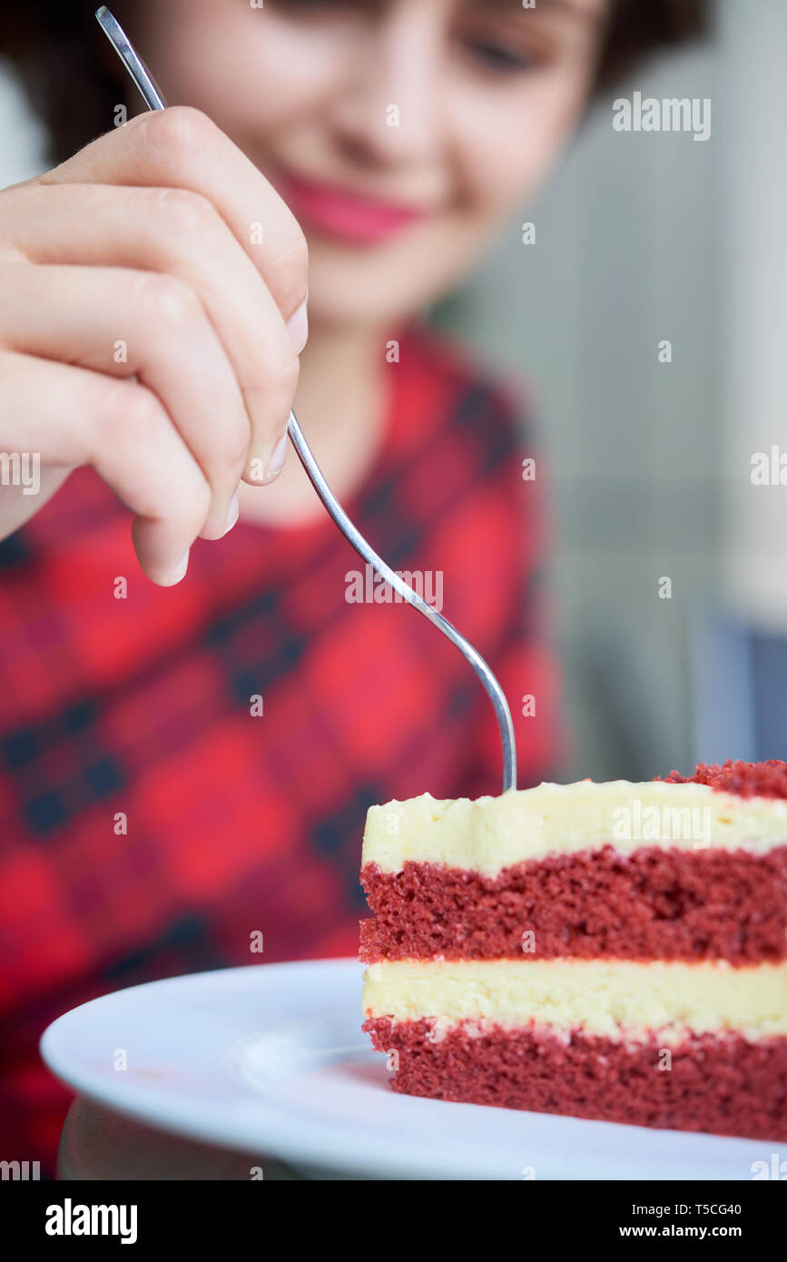 Donna mangiare torta rossa del velluto Foto Stock