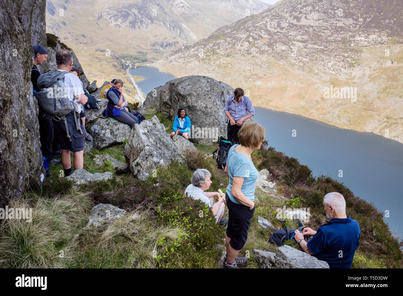 Gli escursionisti in appoggio sul monte Tryfan nord cresta che domina Llyn Ogwen Lago nelle montagne del Parco Nazionale di Snowdonia. Ogwen, Conwy, Wales, Regno Unito, Gran Bretagna Foto Stock