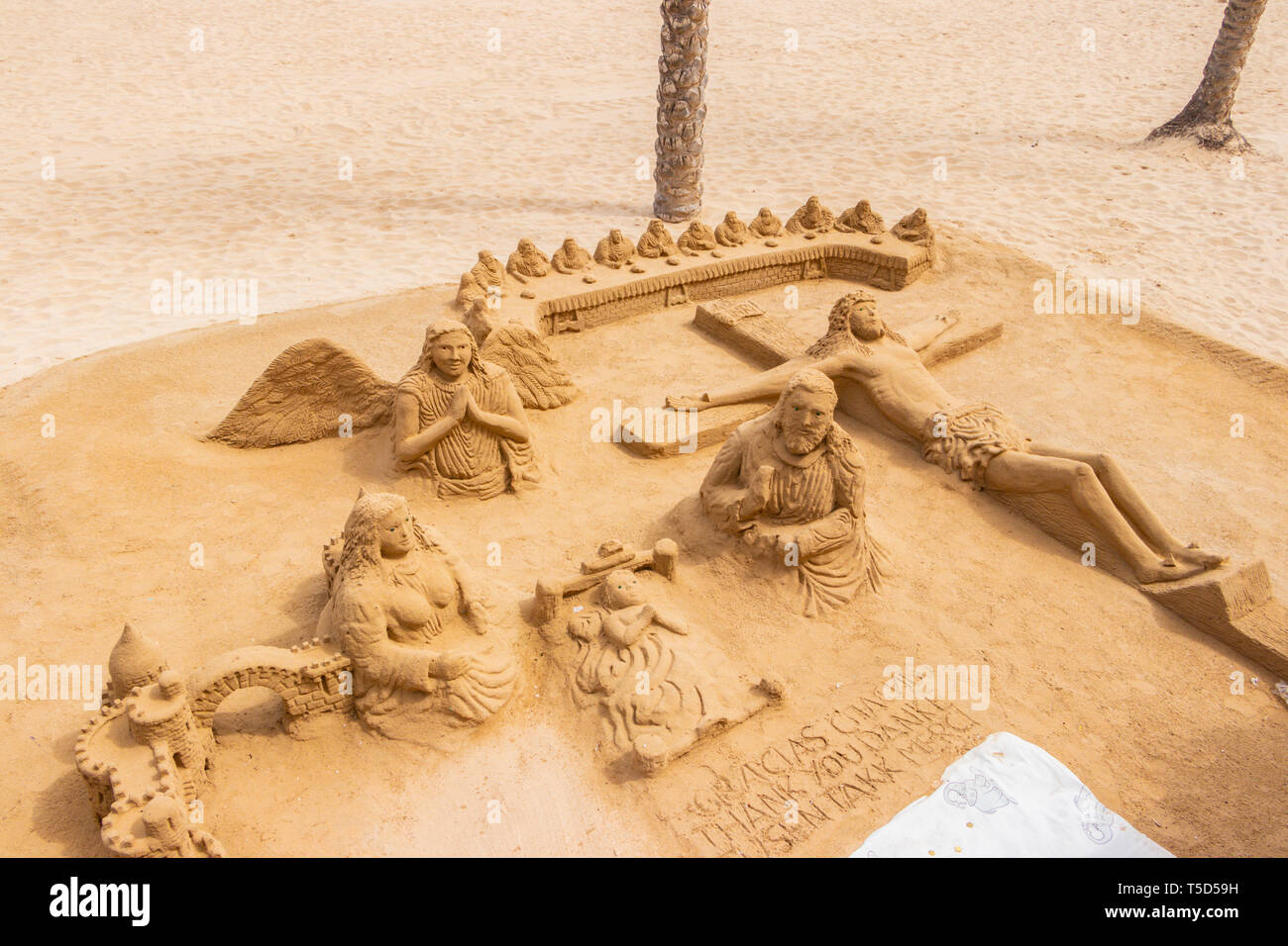 Sculture di sabbia che rappresentano il cristianesimo durante la settimana Santa di Pasqua sulla spiaggia di Alicante Spagna cristo sulla croce Foto Stock