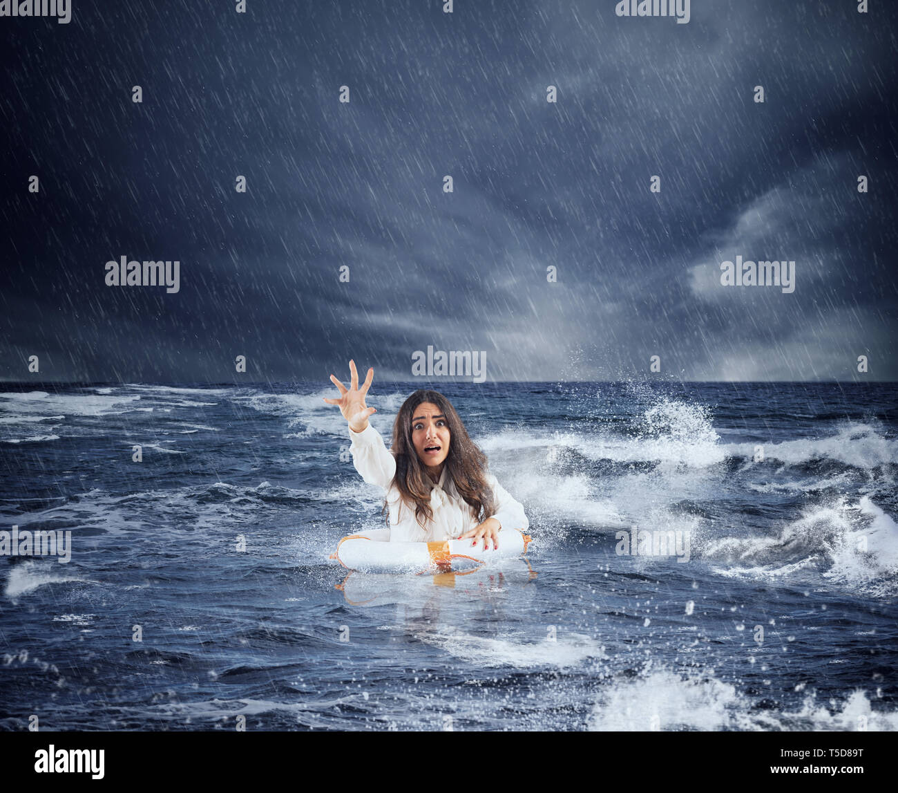 Imprenditrice nell'oceano con lifebelt chiede aiuto durante una tempesta Foto Stock