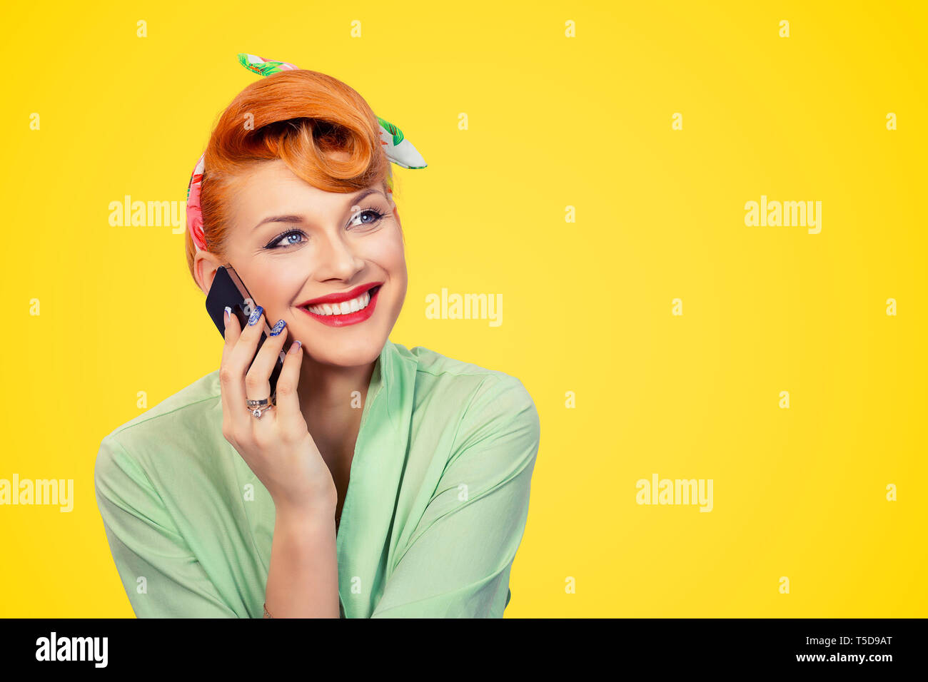 Ritratto di donna bella, pinup ragazza in formale pulsante verde shirt parlando al telefono alla ricerca fino al lato sorridendo felice mentre si sta in piedi sul yello Foto Stock