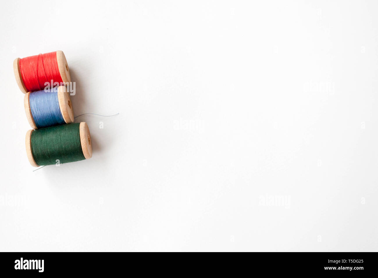 Chiudere fino a tre macchina da cucire bobine con diversi colori di fili  con riflessioni Foto stock - Alamy