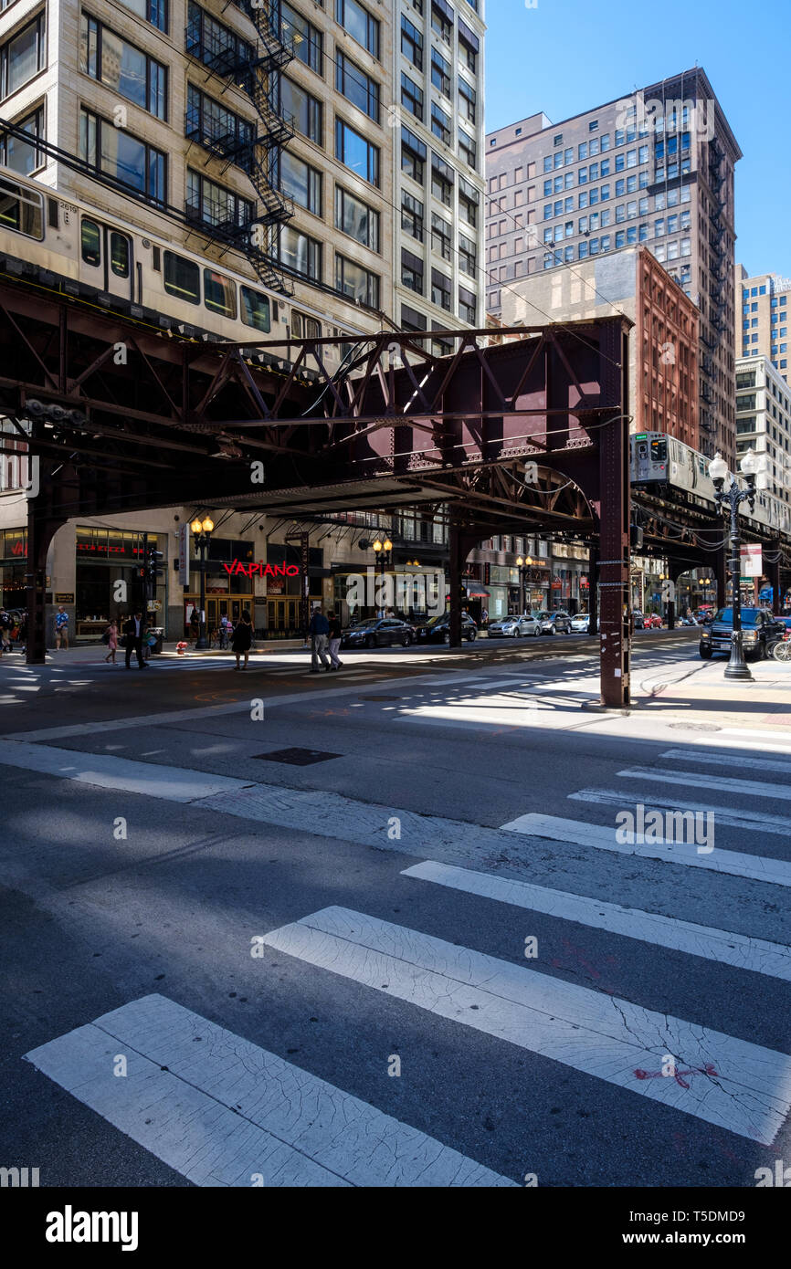 Le strade del centro cittadino di Chicago con il CTA L linea treno per andare al di sopra di Foto Stock