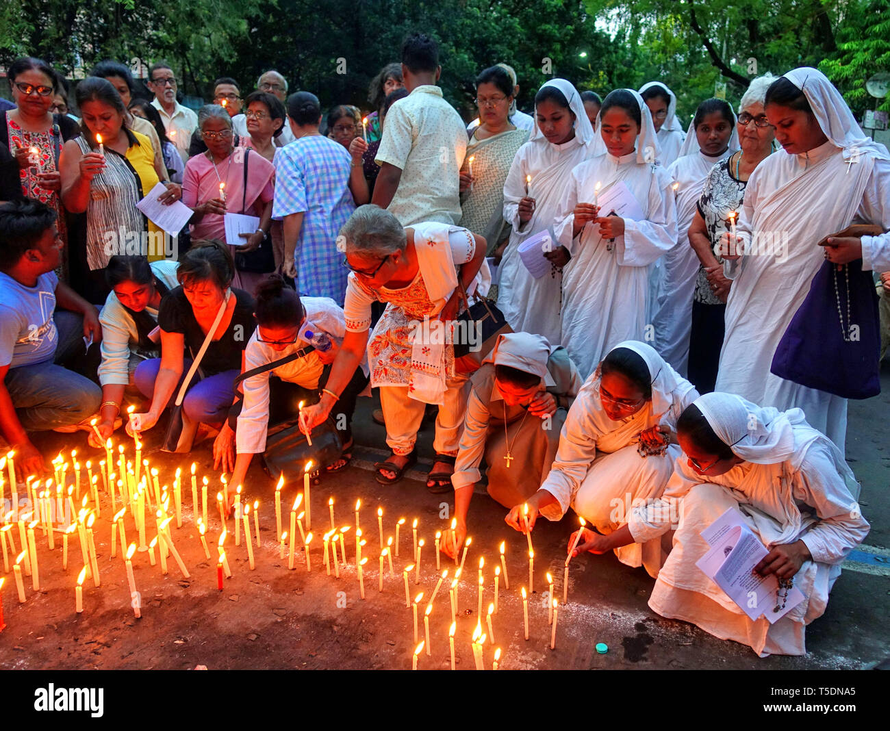 Le monache dall associazione cattolica del Bengala sono visti accendendo candele e mostrando la loro solidarietà per le vittime dello Srilanka a st. Chiesa di San Tommaso a Kolkata. Domenica XXI Aprile almeno 300 persone sono morte in esplosione suicida durante la Pasqua la preghiera da un gruppo terroristico in Srilanka. Foto Stock