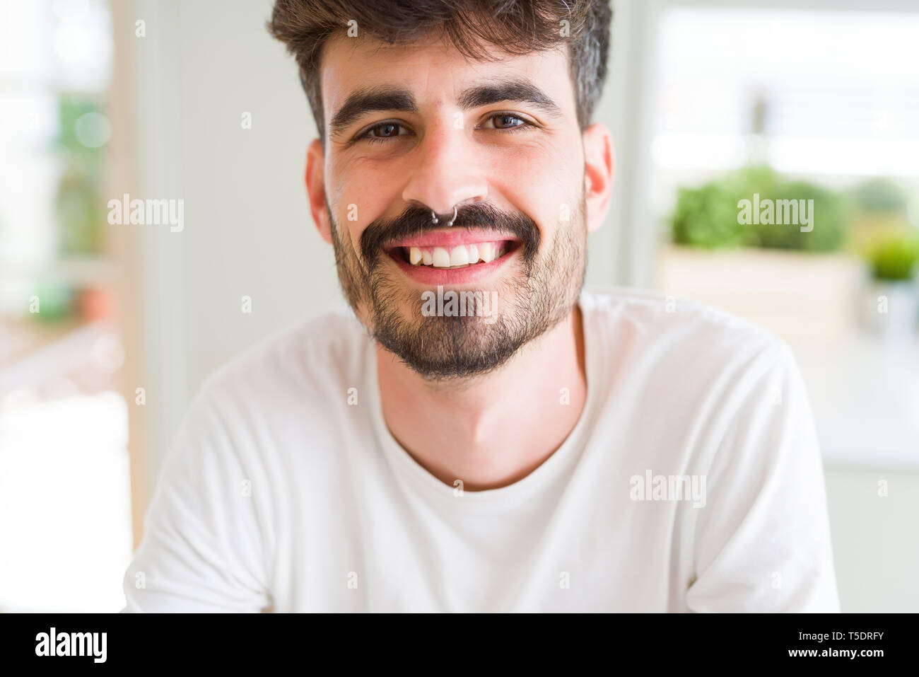 Bel giovane uomo sorridente allegro presso la fotocamera con un grande sorriso sul volto che mostra i denti Foto Stock Bel giovane uomo sorridente allegro presso la fotocamera con un grande sorriso sul volto che mostra i denti Foto Stock