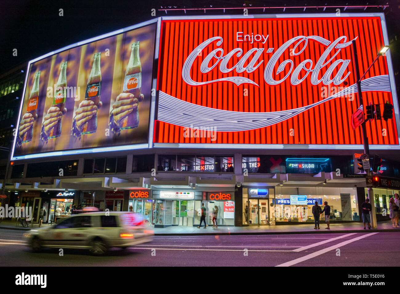 Sydney, Australia - 9 marzo 2017. La Coca-Cola Billboard in Kings Cross, Sydney, con proprietà commerciali e persone a notte. Foto Stock