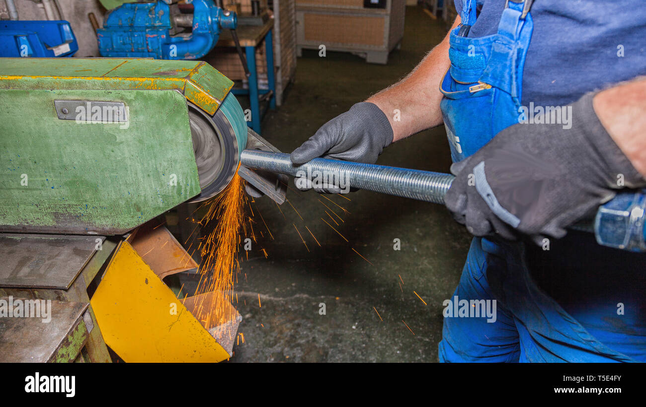 Una mano lavorando su una macchina di molatura. Foto Stock