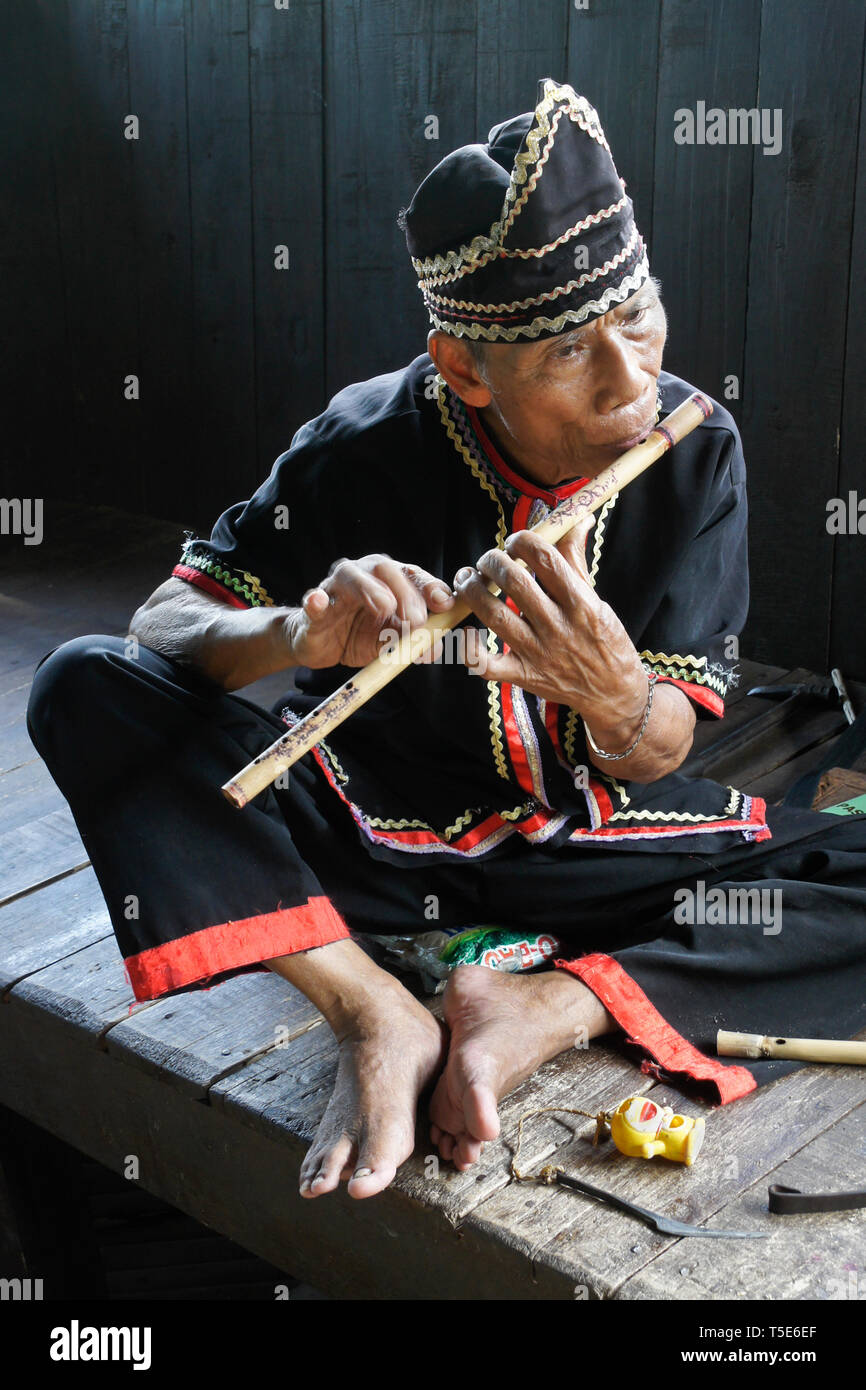 Iban uomo tribale suonare il flauto di Sarawak Villaggio Culturale, Kuching, Sarawak (Borneo), Malaysia Foto Stock