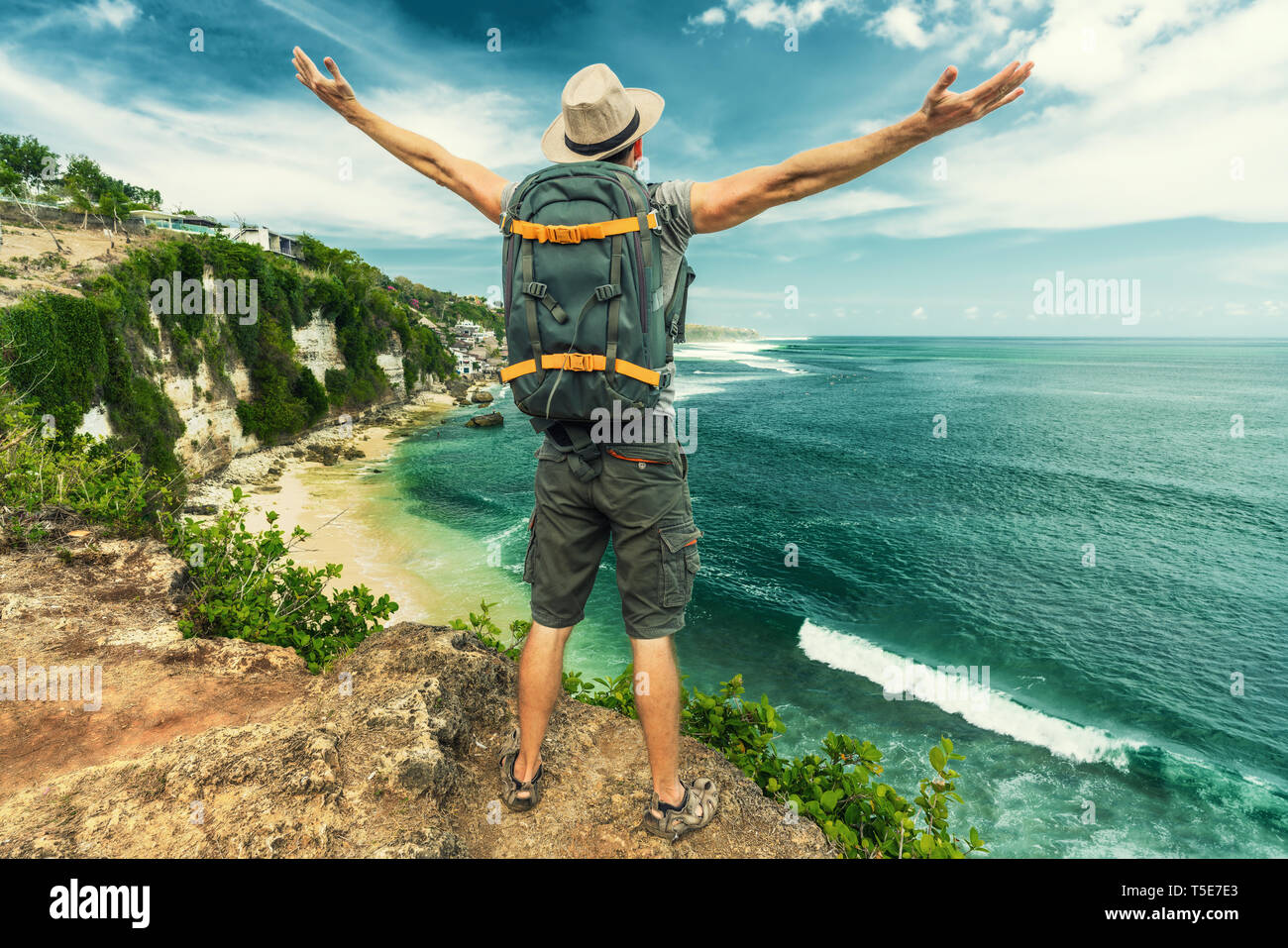 Backpacker uomo sulla cima della scogliera di montagna. Il successo di viaggio uno stile di vita attivo concept outdoor adventure vacanze attive Foto Stock
