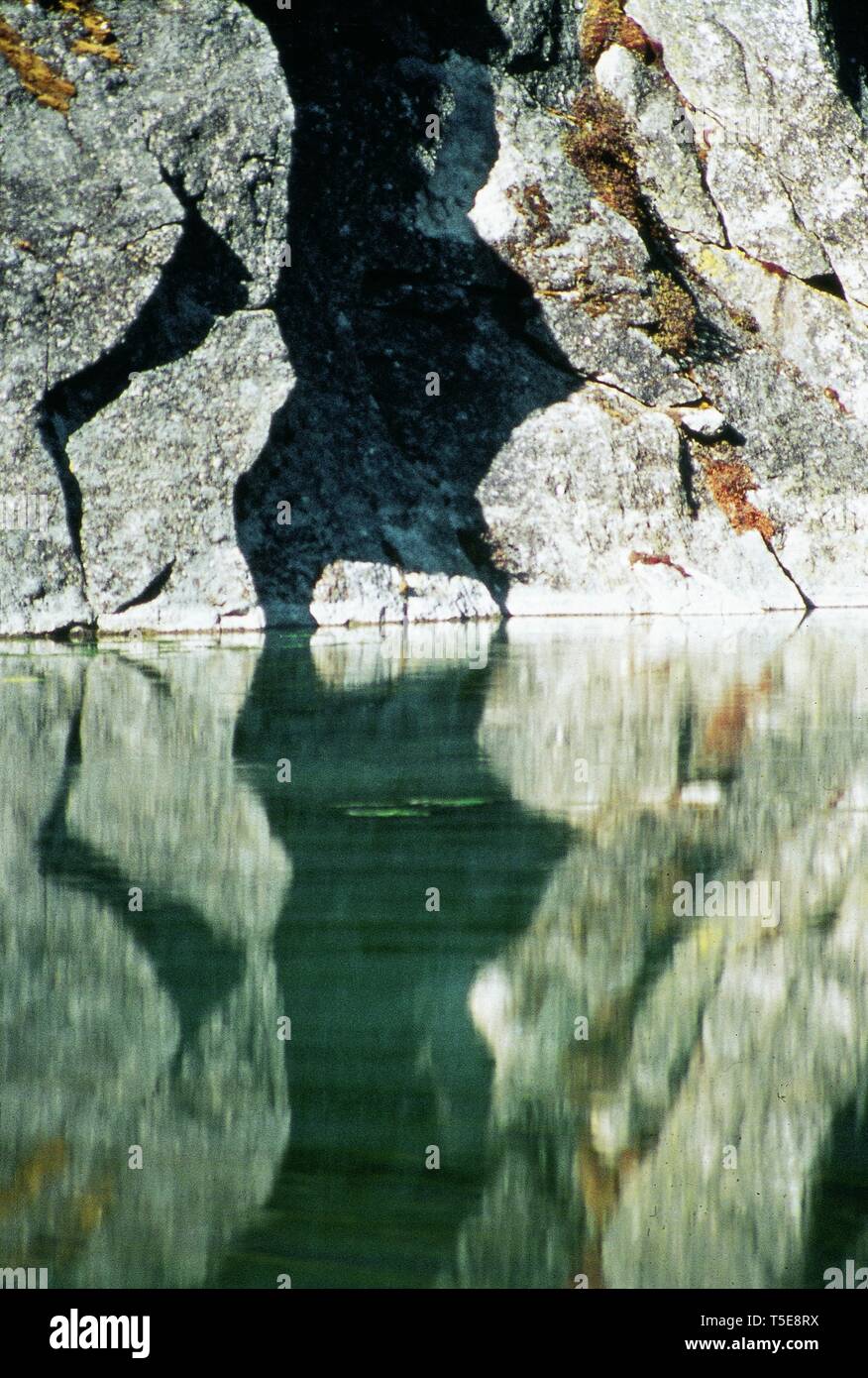 Hard Rock si riflette ancora in acqua di lago di Gokyo, Nepal Foto Stock