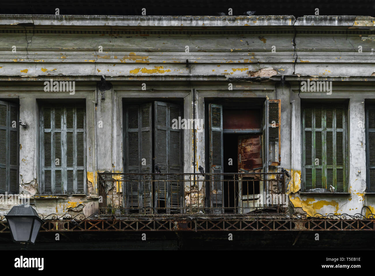 E la vecchia casa abbandonata con qualche seduta sullo stipite piccioni in Atene, Grecia Foto Stock